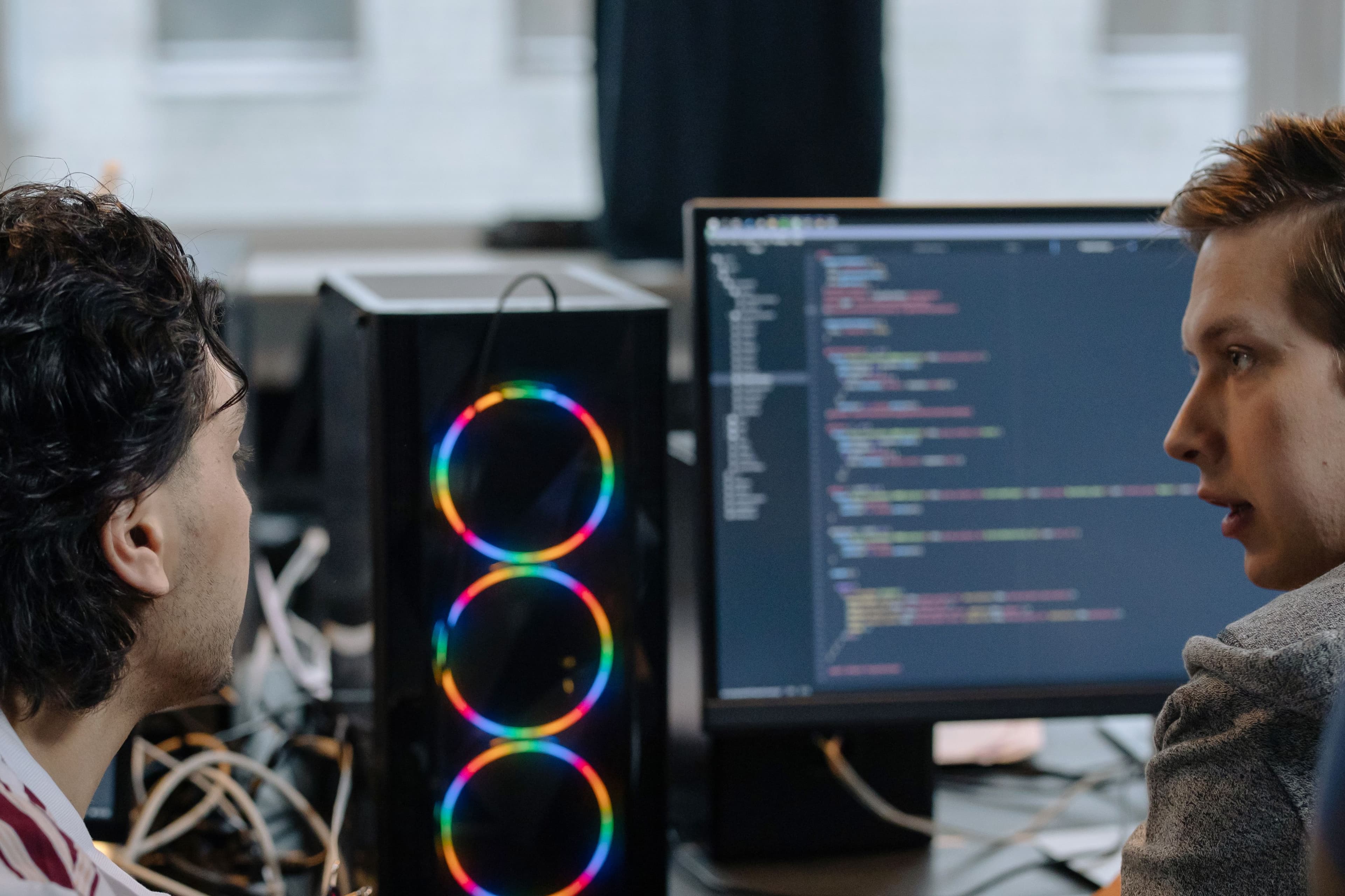 Dois devs analisando código em monitor